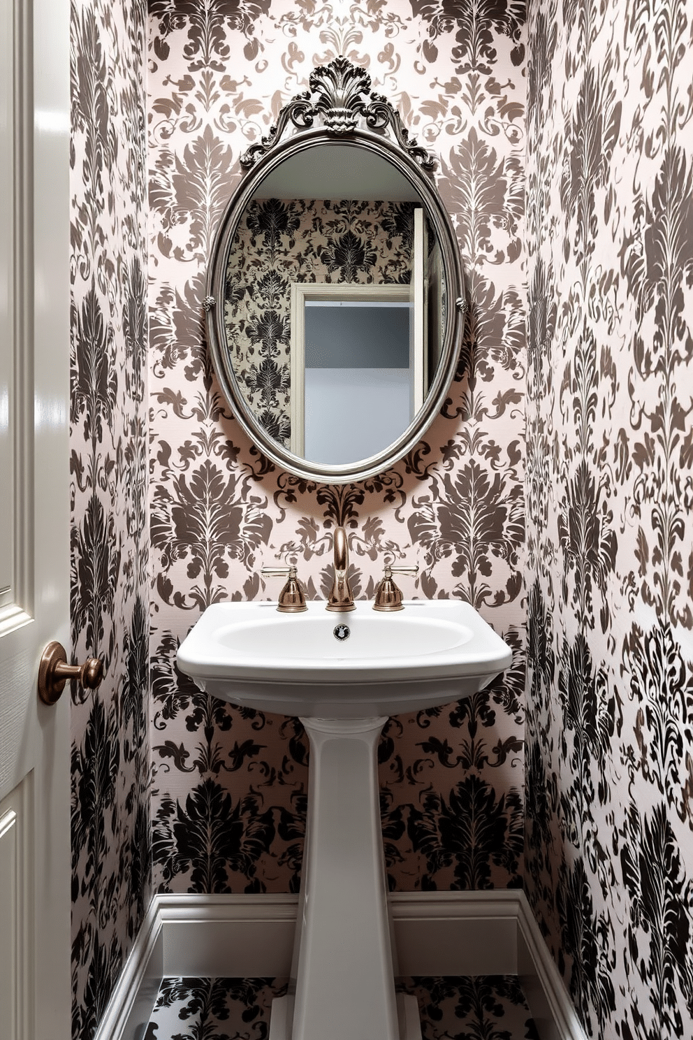 A small powder room featuring elegant wallpaper adorned with bold patterns that create a striking visual impact. The space includes a sleek pedestal sink with a vintage-style faucet, complemented by a round mirror with an ornate frame above it.