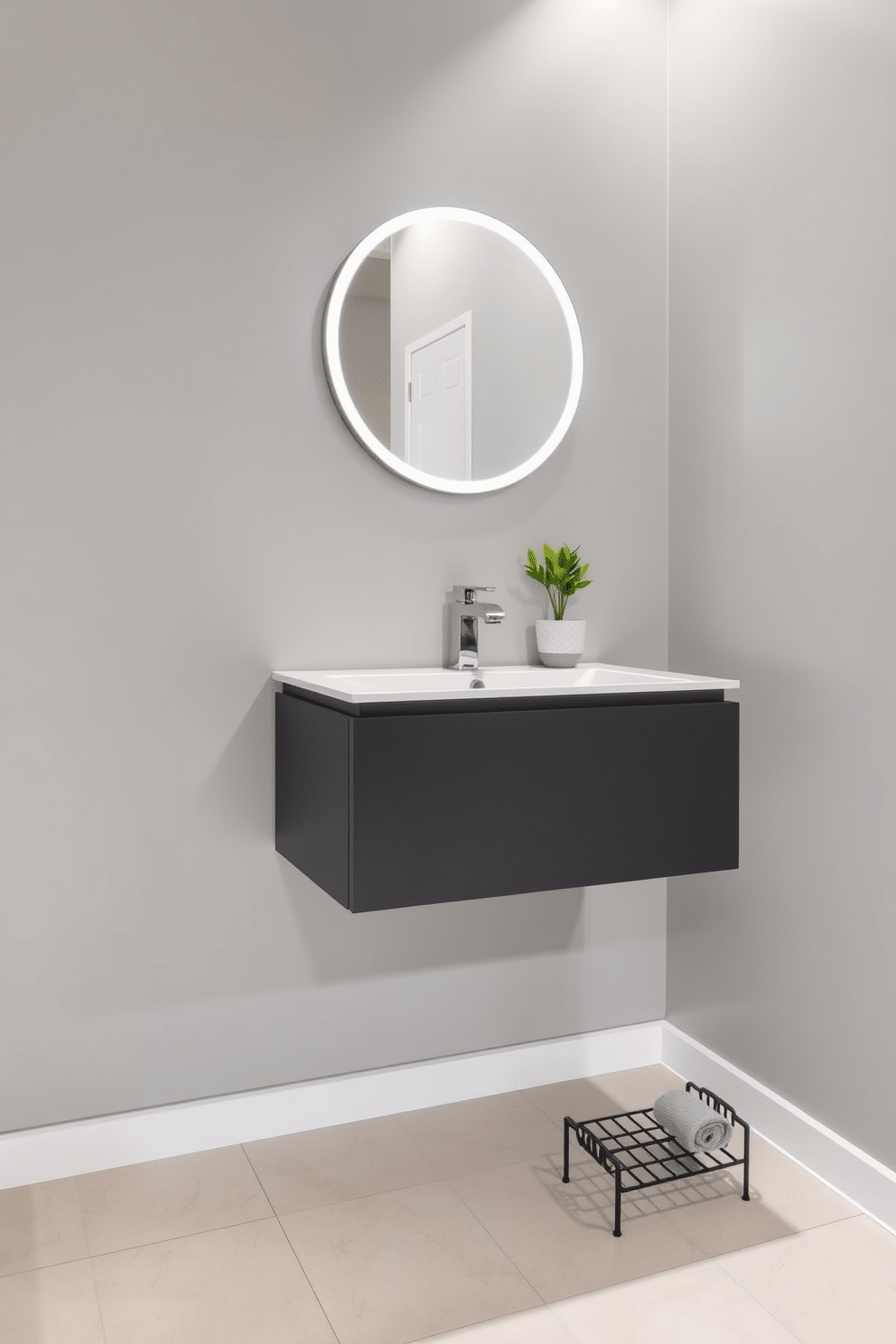 A sleek floating vanity with a minimalist design is mounted against a soft gray wall, creating an illusion of space in a small powder room. Above the vanity, a round mirror with integrated lighting enhances the modern aesthetic, while a stylish faucet adds a touch of elegance. The floor is adorned with large-format tiles in a light tone, complementing the overall airy feel of the room. A small potted plant sits on the countertop, bringing a hint of nature indoors, and a plush hand towel is neatly arranged on a decorative rack.