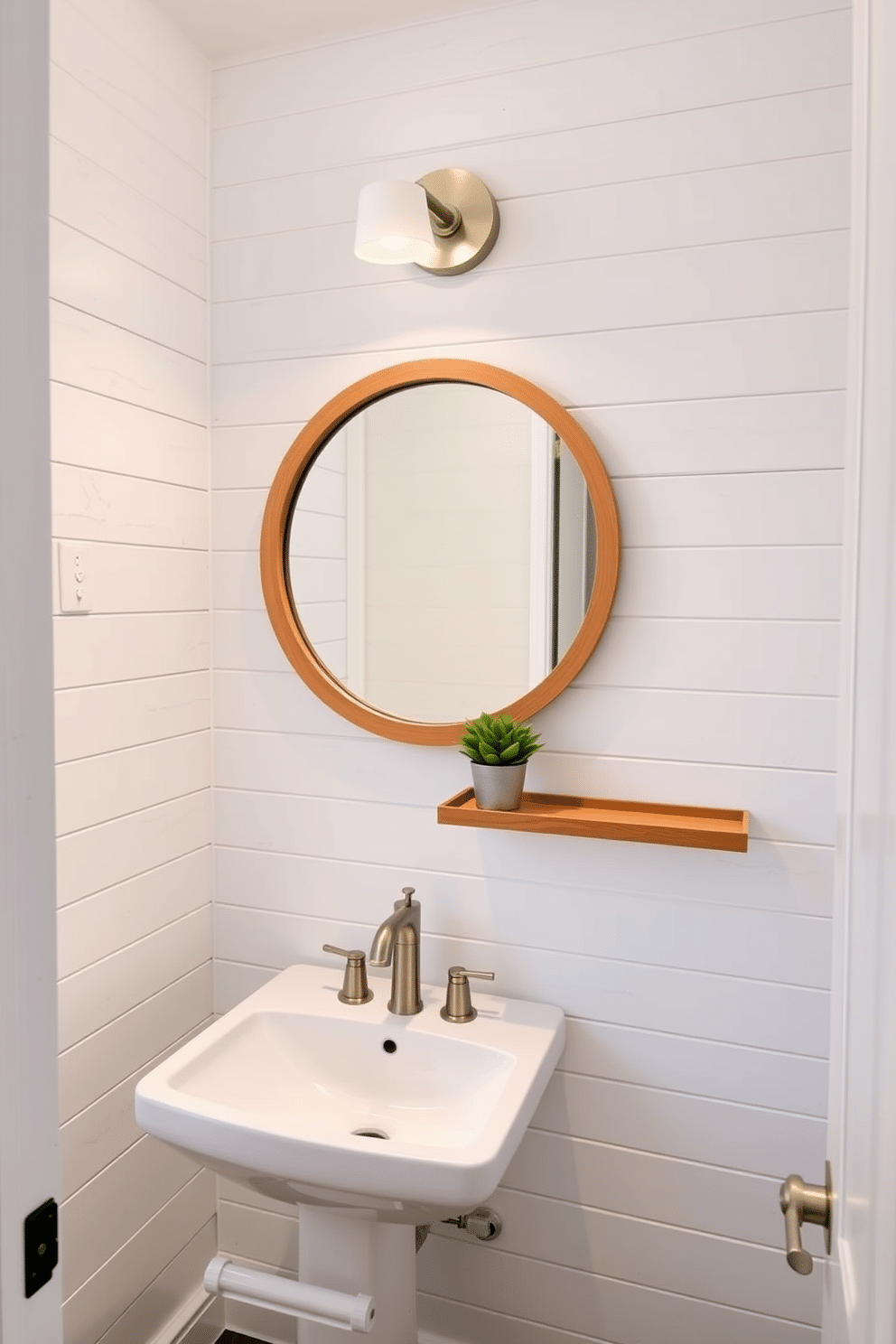 A charming small powder room features an accent wall adorned with white shiplap, creating a cozy yet modern atmosphere. The space is complemented by a sleek pedestal sink and a round mirror framed in natural wood, enhancing the room's rustic elegance. Soft lighting fixtures are mounted above the mirror, casting a warm glow over the room. A small potted plant sits on a floating shelf, adding a touch of greenery to the design.