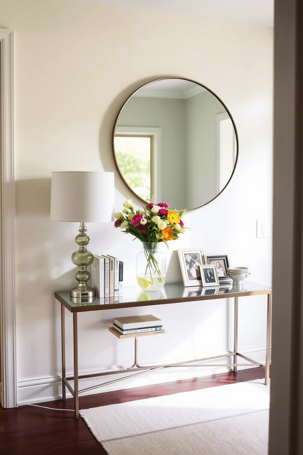 A chic console table is positioned against a soft pastel wall, adorned with a stylish lamp and a collection of decorative books. Above the table, a large round mirror reflects natural light, enhancing the airy feel of the space. On the console, a vibrant vase filled with fresh spring flowers adds a pop of color, while a few framed photos create a personal touch. The hallway is accented with a runner rug in light hues, complementing the overall decor and inviting guests into the home.