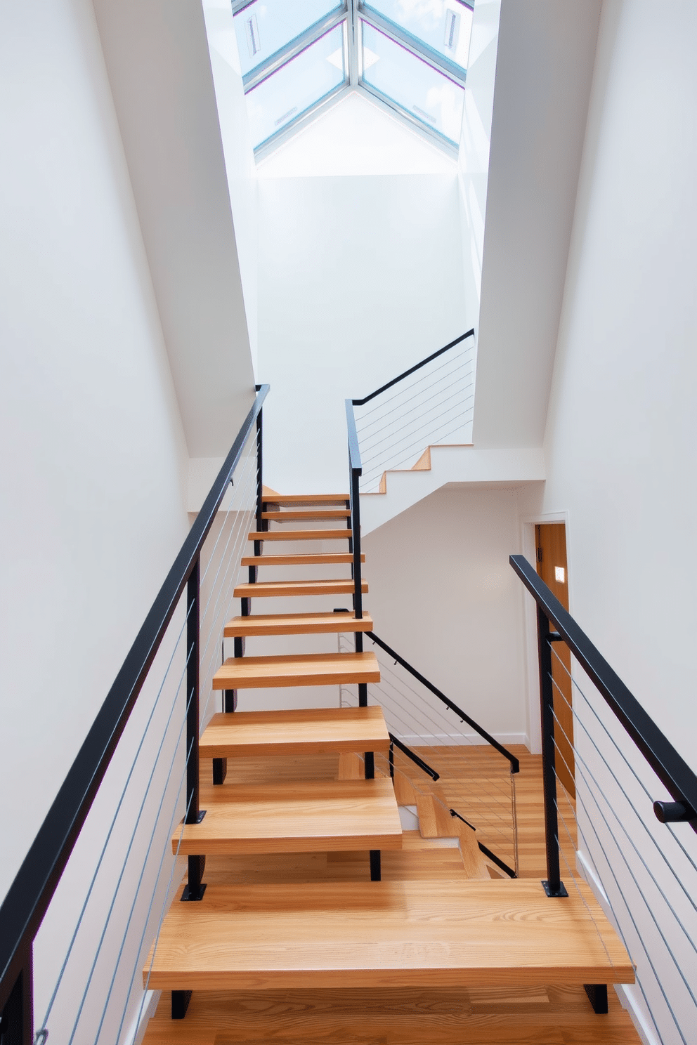 A contemporary staircase with open treads showcases a sleek design that emphasizes light and space. The treads are made of polished oak, creating a warm contrast against the minimalist metal railing that is finished in matte black. Natural light floods the area through a large skylight above, illuminating the staircase and enhancing the airy feel of the space. The walls are painted in a soft white, allowing the staircase to be the focal point of the entryway.