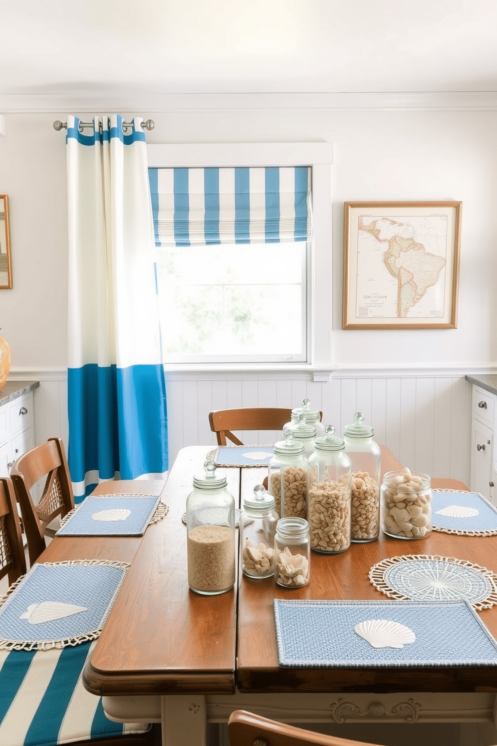 A cheerful summer kitchen adorned with nautical elements. There are bright blue and white striped curtains framing the windows, and a rustic wooden table set with seashell-themed placemats. On the walls, framed vintage maps of coastal regions add a touch of adventure. A collection of glass jars filled with sand and small shells decorates the countertop, bringing the beach indoors.