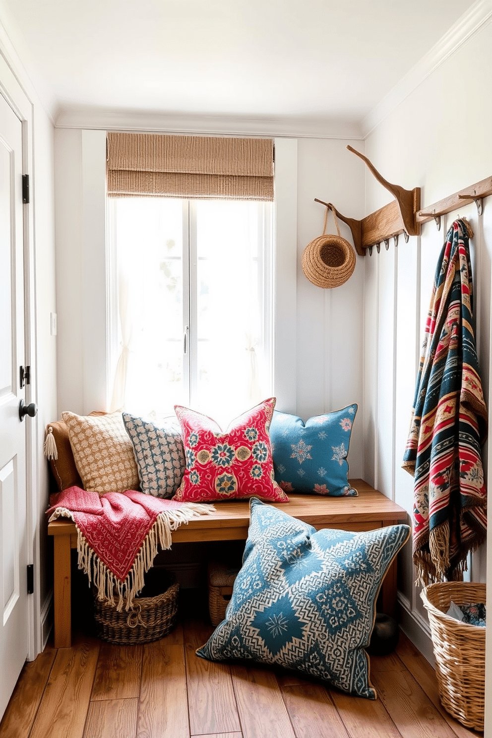 A cozy mudroom filled with summer vibes. Soft woven throws and vibrant cushions in various patterns are layered on a bench, inviting comfort. Natural light floods the space through a large window adorned with sheer curtains. The walls are painted a warm white, and the floor features rustic wooden planks, enhancing the inviting atmosphere.