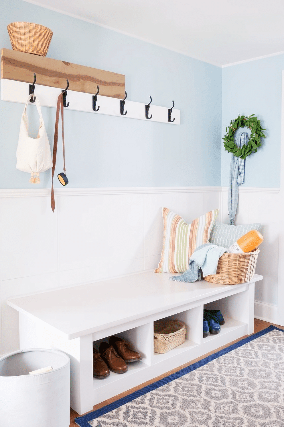 A bright and airy summer mudroom features a spacious bench with built-in storage underneath for shoes and outdoor gear. The walls are painted in a soft blue hue, complemented by white shiplap accents and a cheerful patterned rug. To personalize the space, consider adding a DIY project such as a custom coat rack made from reclaimed wood and vintage hooks. Decorate the bench with colorful throw pillows and a woven basket filled with summer essentials like sunscreen and beach towels.