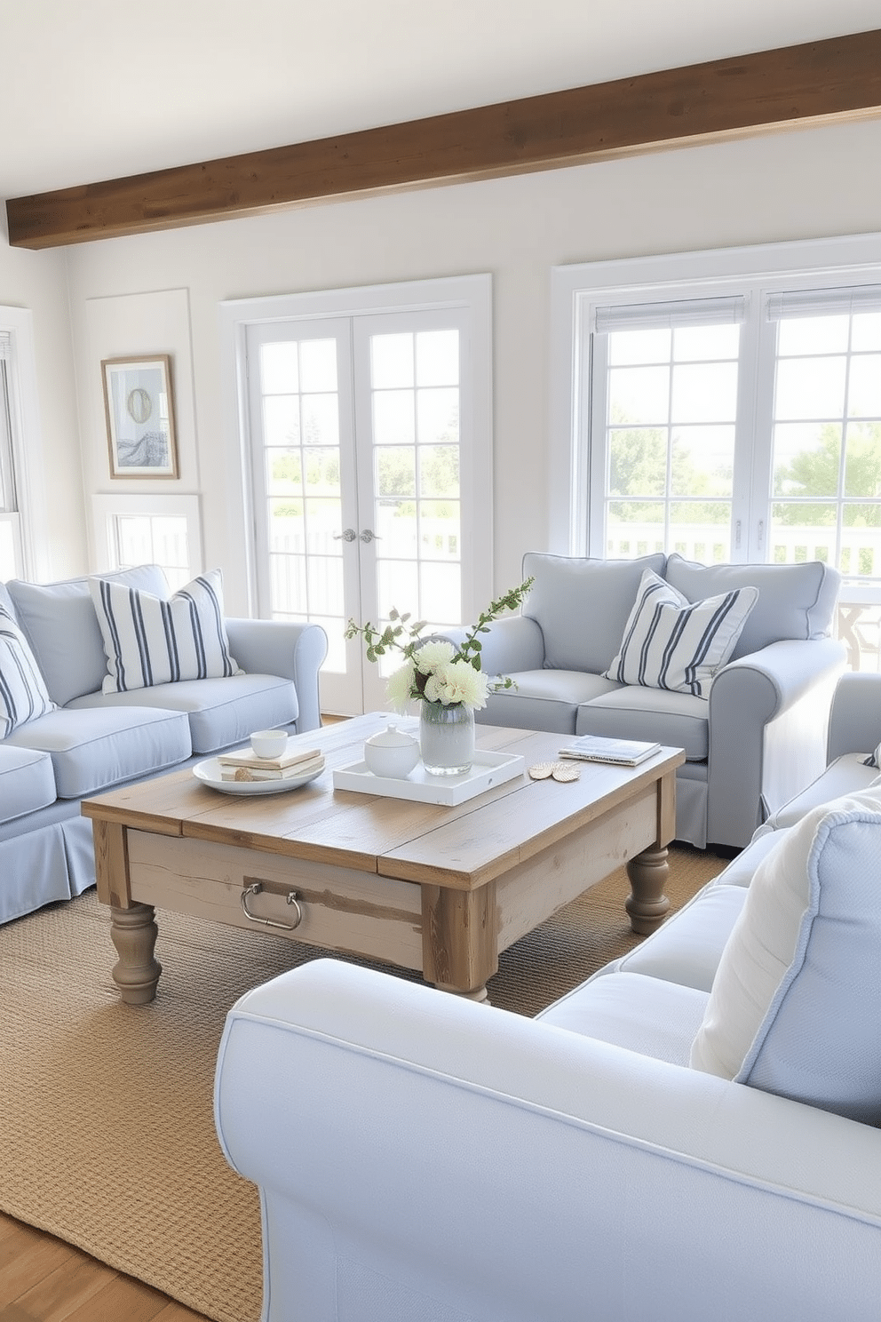 A coastal-themed coffee table is the centerpiece of a bright and airy summer small living room. The table is made of reclaimed wood, featuring a weathered finish that complements the light, sandy hues of the decor. Surrounding the coffee table are soft, plush sofas upholstered in light blue fabric, adorned with white and navy striped cushions. Natural light floods the room through large windows, enhancing the fresh and inviting atmosphere.