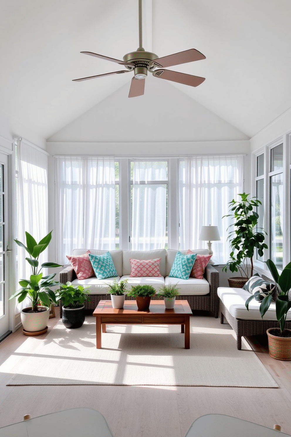 A bright and airy sunroom filled with natural light. The space features large windows with sheer white curtains, allowing sunlight to filter through while maintaining privacy. In the center, a comfortable sectional sofa is adorned with colorful throw pillows. A wooden coffee table sits in front, surrounded by potted plants that add a touch of greenery. A stylish ceiling fan hangs from the vaulted ceiling, providing a gentle breeze on warm summer days. The floor is covered with a soft, light-colored area rug that complements the overall decor.