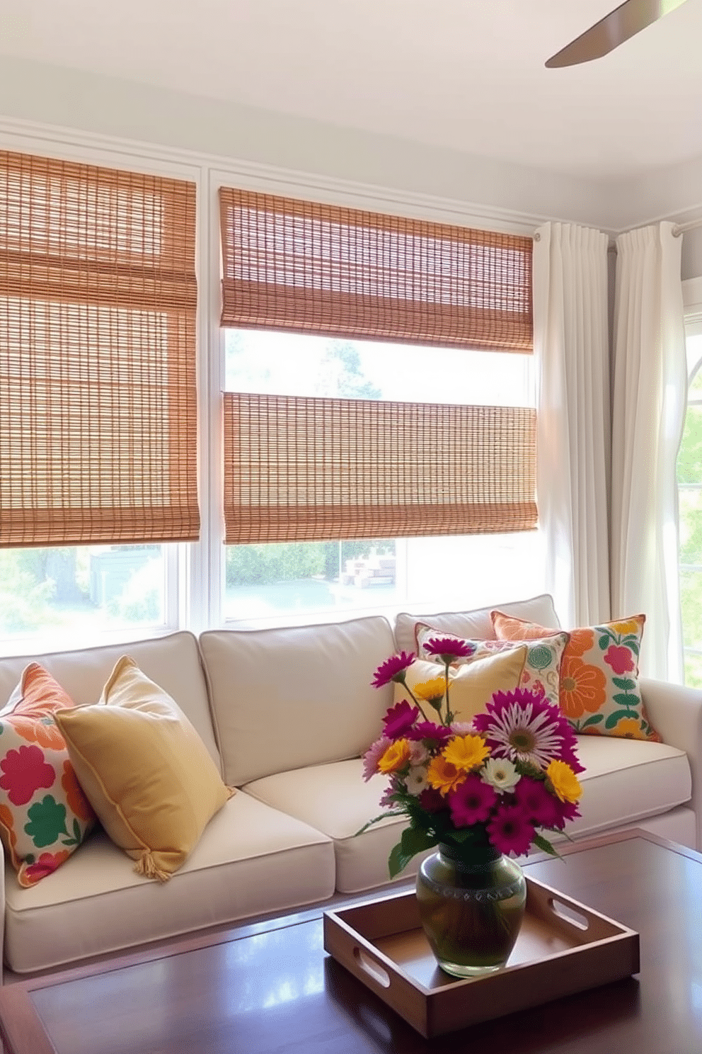 A bright and airy living room features woven bamboo shades that filter sunlight, creating a warm and inviting atmosphere. The shades are paired with light, breezy curtains that flutter gently in the summer breeze, enhancing the natural aesthetic of the space. Colorful throw pillows in vibrant summer hues are arranged on a comfortable sofa, adding a playful touch to the decor. Fresh flowers in a vase on the coffee table bring a pop of color and a sense of freshness to the room.