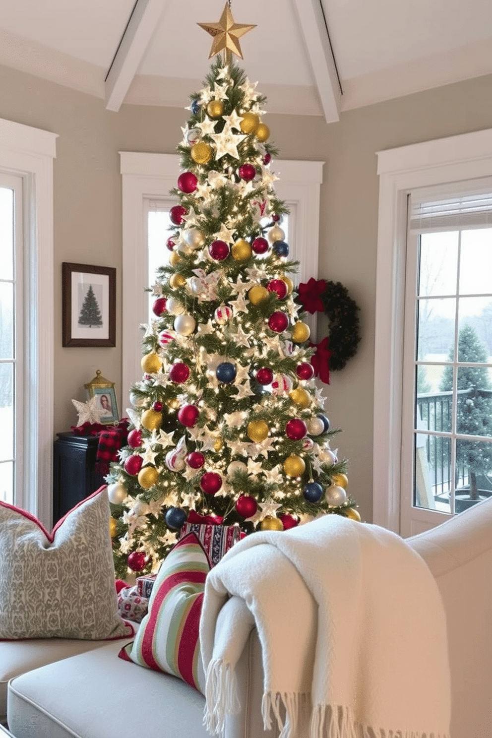 A stunning Christmas tree centerpiece adorned with twinkling white lights and an array of colorful ornaments stands tall in the sunroom. Surrounding the tree, comfortable seating is arranged with festive throw pillows, and a soft, cozy blanket drapes over the armrest, inviting warmth and holiday cheer.