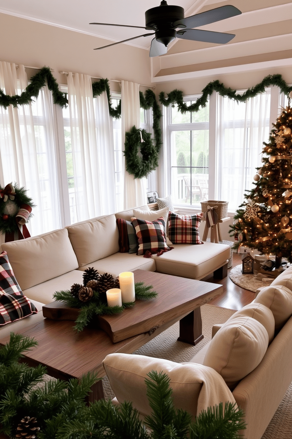 A cozy sunroom adorned for Christmas, featuring a mix of modern and rustic decor elements. A large, comfortable sectional sofa is draped with plaid throw blankets, while a rustic wooden coffee table holds a centerpiece of pinecones and candles. The windows are framed with sheer white curtains, allowing natural light to illuminate the space. A beautifully decorated Christmas tree stands in one corner, adorned with twinkling lights and handmade ornaments, complementing the surrounding greenery.