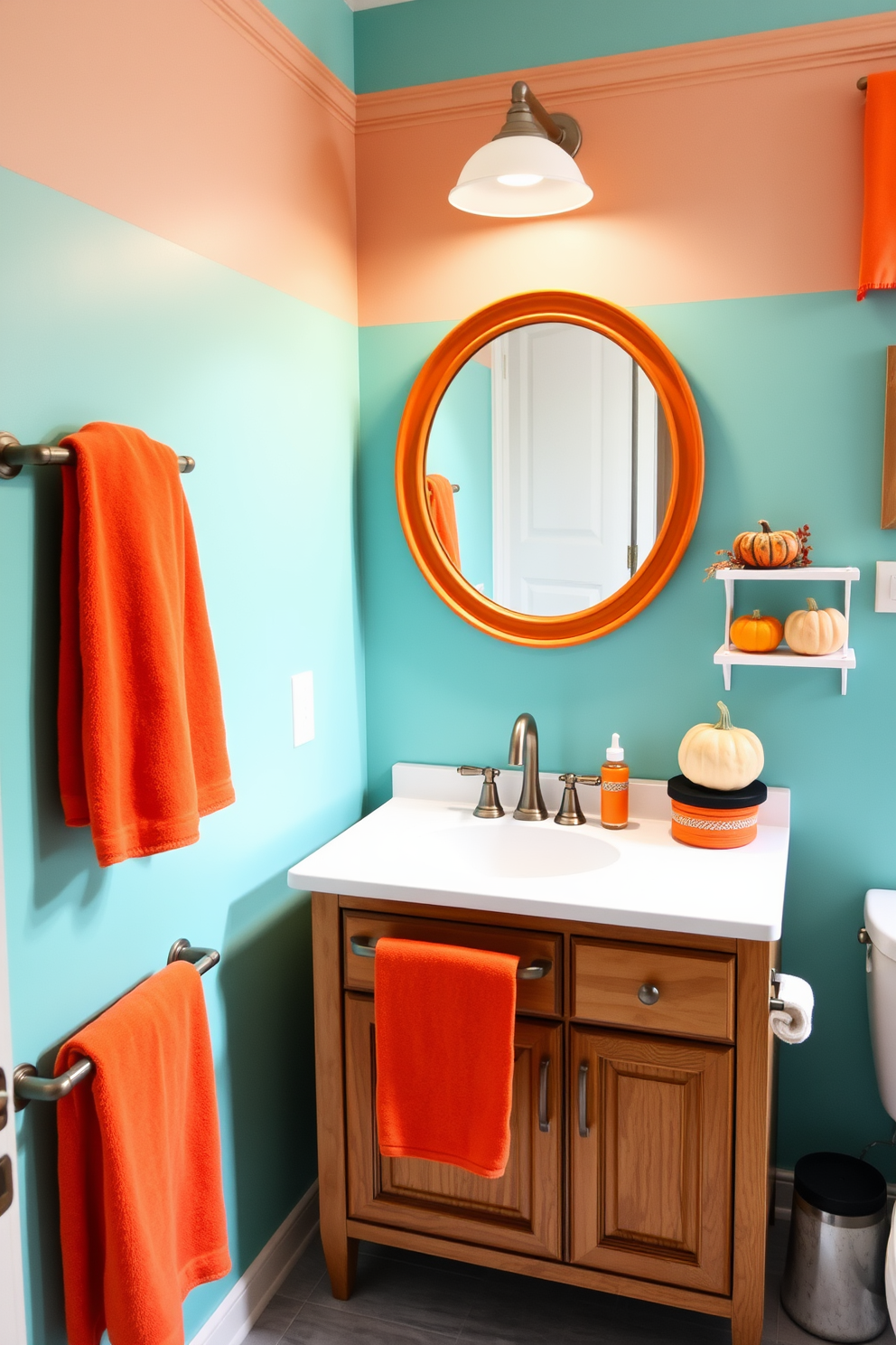 A vibrant bathroom setting featuring a turquoise and orange color scheme. The walls are painted a soft turquoise while orange accents are incorporated through towels and decorative items. A wooden vanity with a white countertop holds a large round mirror framed in orange. To the side, a small shelf displays pumpkins and autumn-themed decor, adding a festive touch for Thanksgiving.