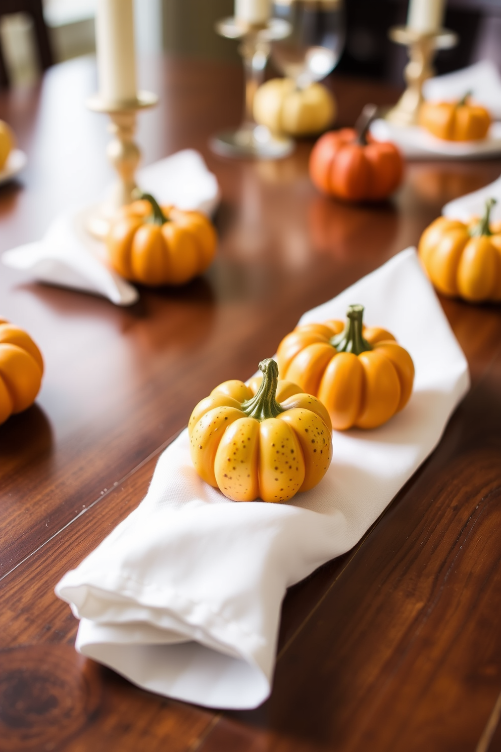 Mini pumpkins serve as charming individual place settings for a Thanksgiving table. Each pumpkin is uniquely painted in warm autumn colors and placed on a crisp white napkin, creating a cozy and inviting atmosphere.