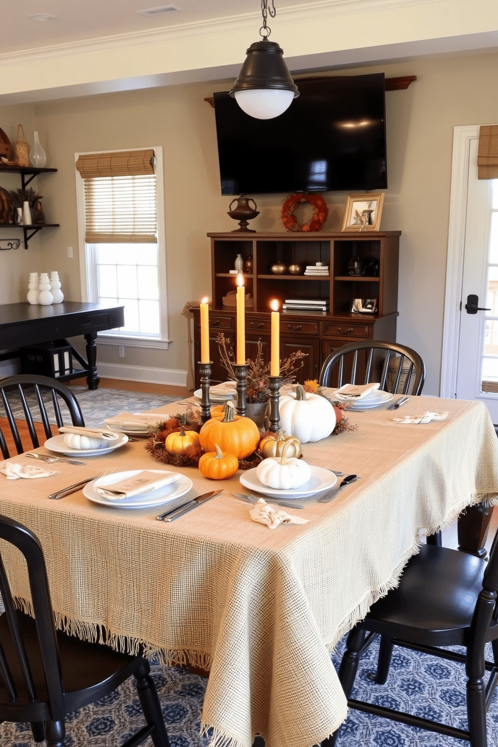 A cozy game room adorned with a burlap tablecloth that adds rustic charm. The table is set with autumn-themed decorations, including pumpkins and warm-toned candles, creating an inviting atmosphere for Thanksgiving festivities.