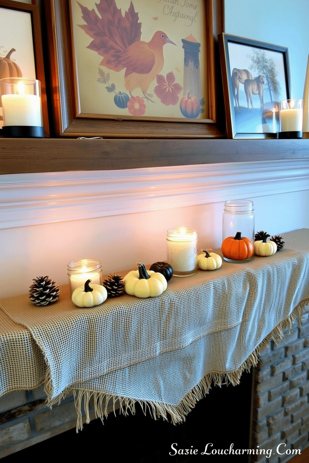 A cozy Thanksgiving mantel adorned with burlap accents creates a warm and rustic atmosphere. The mantel features a layered burlap runner, complemented by small pumpkins and pinecones arranged artfully along its length. Above the mantel, a collection of autumn-themed artwork is framed in weathered wood. Flickering candles in mason jars add a soft glow, enhancing the inviting charm of the space.