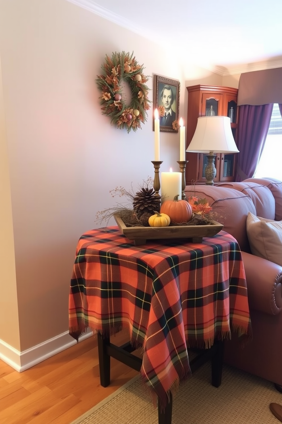 A cozy small living room features a side table draped with a plaid tablecloth in warm autumn colors. On top of the table, a rustic centerpiece holds pumpkins and candles, enhancing the Thanksgiving ambiance.