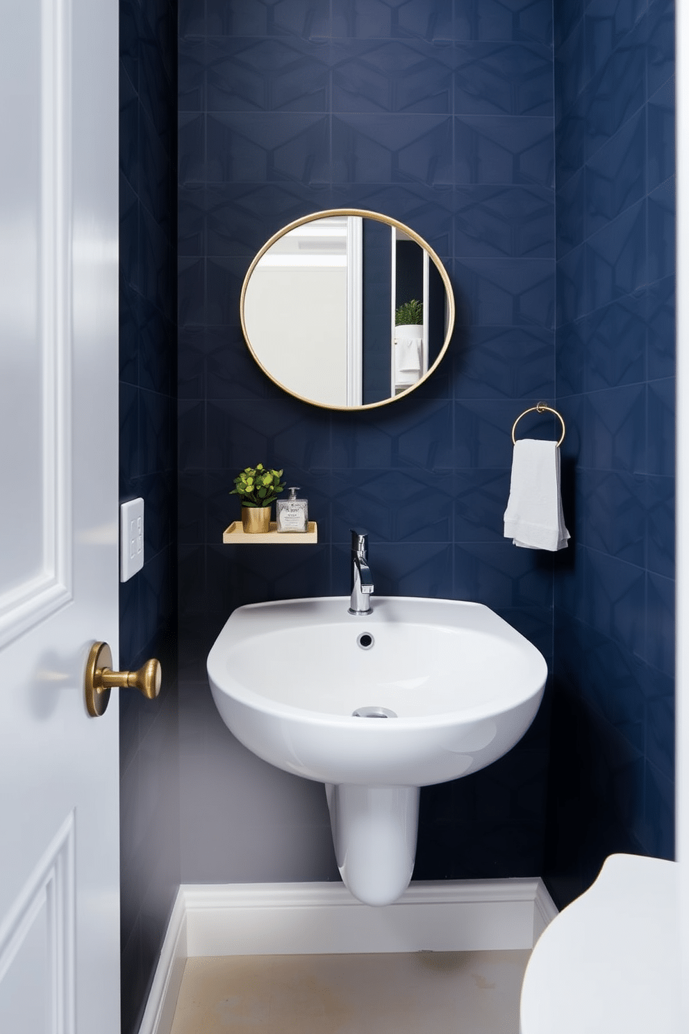 A sleek wall-mounted sink is positioned in the corner of a compact powder room, maximizing floor space and creating an airy feel. The walls are adorned with a bold, geometric wallpaper in deep navy, while a small round mirror with a brass frame reflects the stylish decor. A minimalist floating shelf above the sink holds a few decorative items, including a small potted plant and elegant hand soap. The floor is covered in light-colored tiles, providing a contrast to the darker walls and enhancing the room's overall brightness.