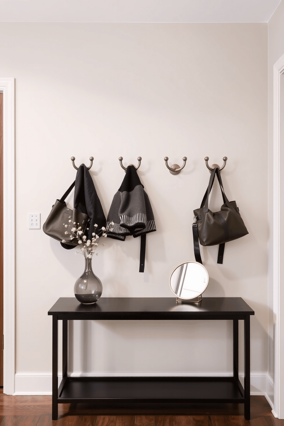 A stylish townhouse entryway features decorative hooks mounted on a sleek wall, providing easy access for coats and bags. The hooks are arranged in a modern pattern, complemented by a minimalist console table beneath them, adorned with a chic vase and a small mirror to enhance the space.