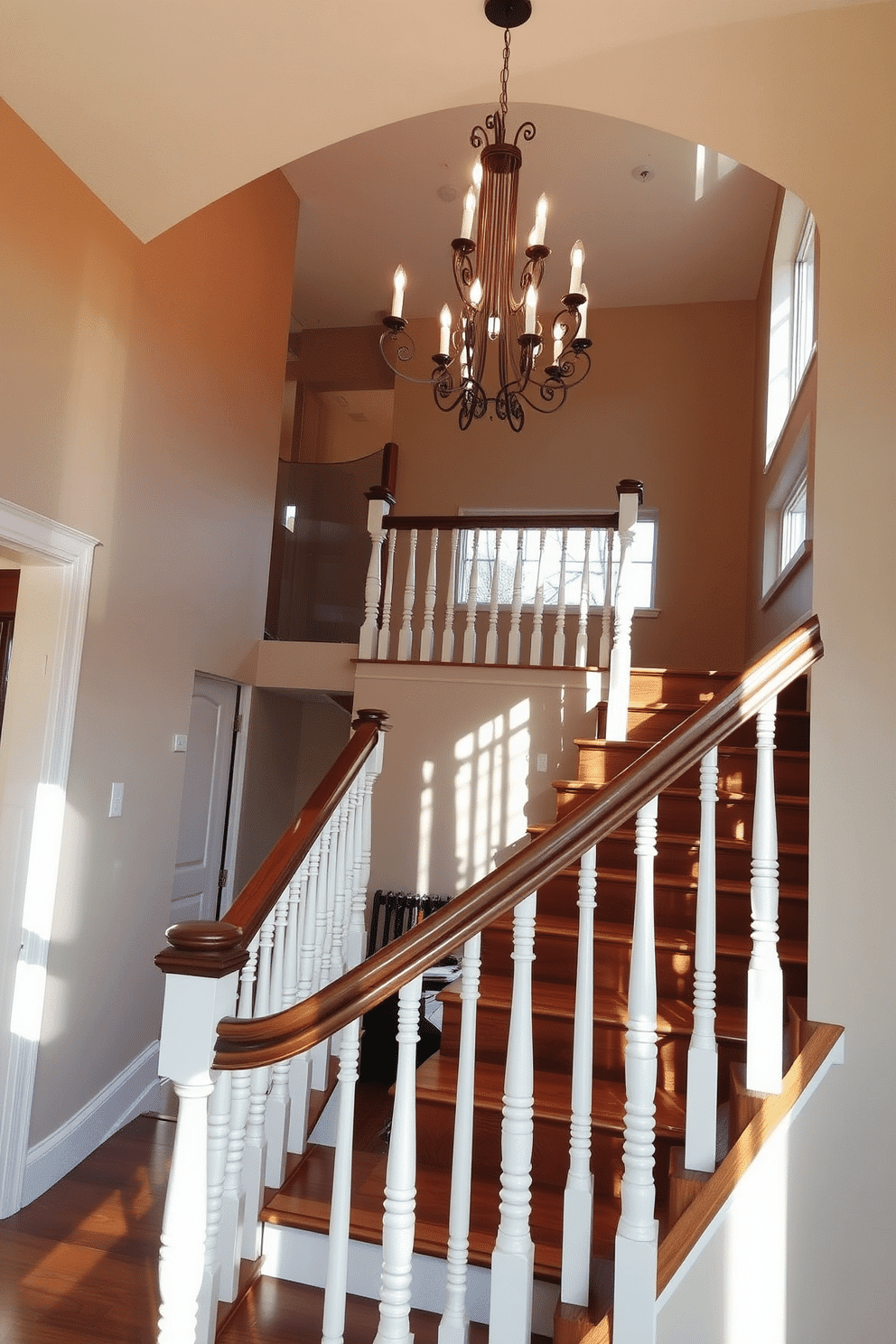 Open riser staircase with decorative spindles, showcasing elegant craftsmanship and a blend of modern and traditional elements. The treads are made of rich hardwood, while the spindles feature intricate detailing, painted in a soft white for contrast. The staircase is illuminated by a statement chandelier hanging above, casting a warm glow on the surrounding walls. Natural light floods in from a large window nearby, enhancing the inviting atmosphere of the space.