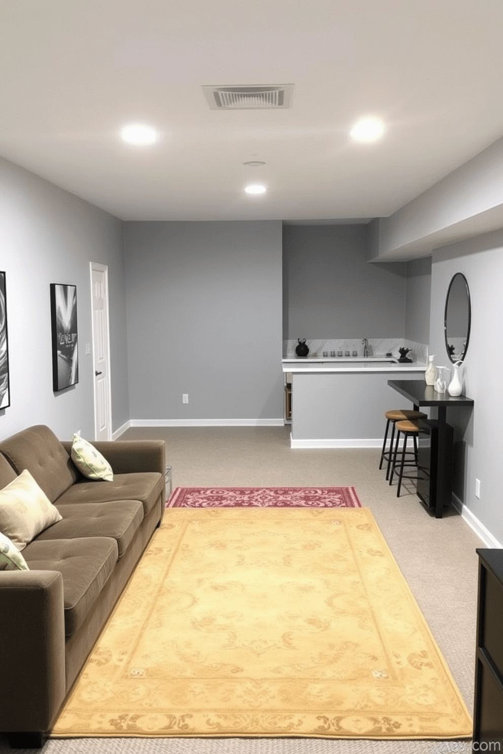 A cozy unfinished basement transformed into a functional living space. A large area rug in a warm, neutral tone anchors the seating area, creating a defined space for relaxation and entertainment. The walls are painted a soft gray, enhancing the brightness of the room. In one corner, a stylish bar area is set up, with a sleek countertop and bar stools, complemented by a decorative rug that adds a pop of color.