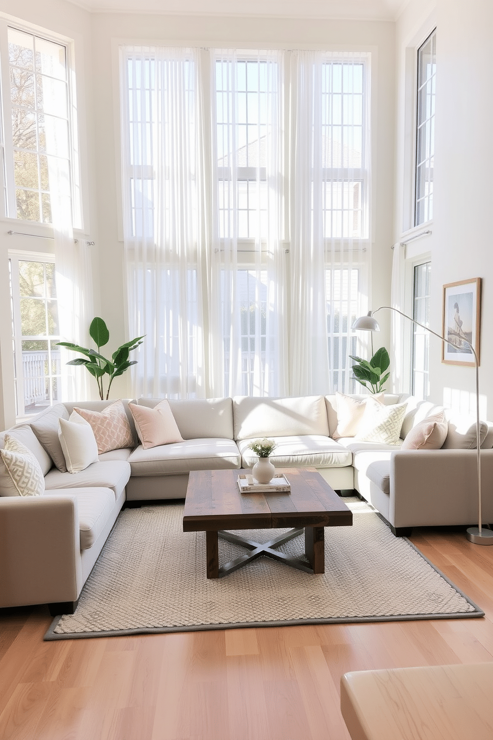 A bright and airy family room filled with natural light, featuring soft white curtains that gently frame large windows. The space is adorned with a plush sectional sofa in light gray, complemented by pastel-colored throw pillows and a cozy area rug underneath. A modern coffee table sits at the center, made of reclaimed wood with a sleek glass top. On the walls, framed artwork in soft hues adds a touch of personality, while a stylish floor lamp provides warm illumination in the evenings.