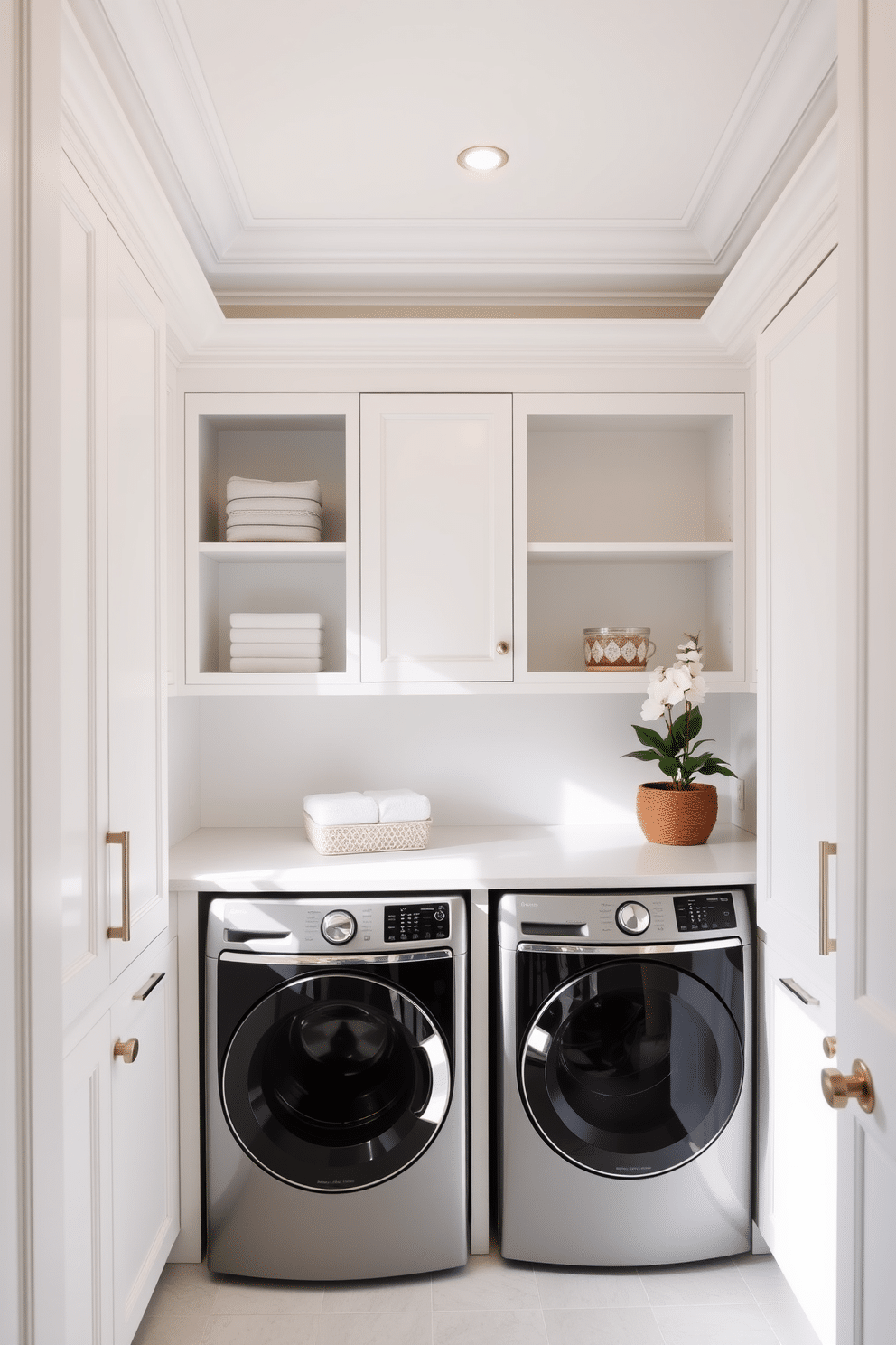 A bright and airy laundry room featuring elegant crown molding that adds a touch of sophistication to the space. The walls are painted in a soft white hue, complemented by a sleek, modern washer and dryer set, seamlessly integrated into custom cabinetry. The cabinetry showcases a mix of open shelving and closed storage, allowing for both decorative displays and practical organization. A stylish countertop made of quartz provides ample space for folding laundry, while a chic laundry basket and potted plant add warmth and personality to the room.