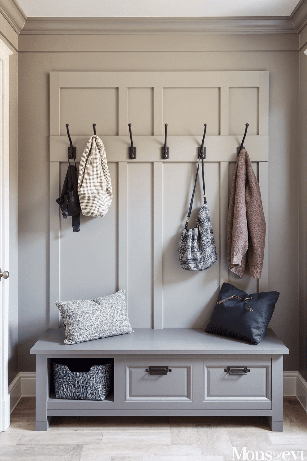 A stylish mudroom featuring wall-mounted hooks for easy access, designed with a blend of functionality and aesthetics. The walls are painted in a soft gray, complemented by a durable bench with storage underneath, creating an inviting and organized entryway.