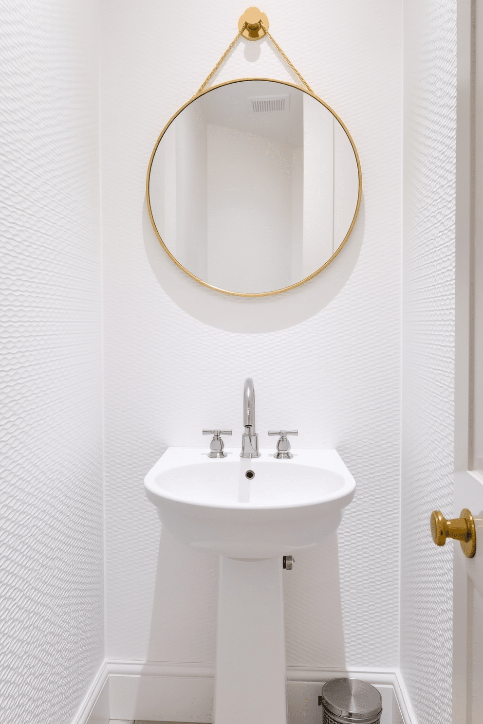 A chic powder room featuring textured wallpaper that adds depth and elegance to the space. The walls are adorned with a subtle, raised pattern in soft white tones, enhancing the room's brightness and sophistication. In the center, a sleek white pedestal sink is complemented by a modern faucet, creating a clean and minimalist look. A round mirror with a thin gold frame hangs above the sink, reflecting the stylish design elements of the room.