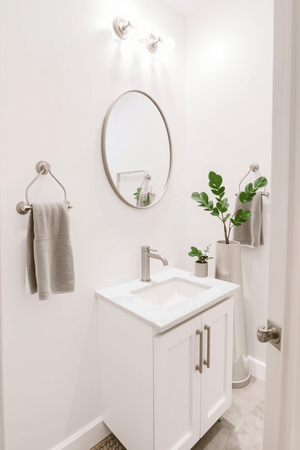 A chic powder room featuring stylish towel racks in brushed nickel, elegantly mounted on the wall. The space is adorned with a sleek white vanity topped with a polished marble surface, complemented by a round mirror framed in brushed nickel above it. The walls are painted in a soft white hue, creating a fresh and airy atmosphere. A decorative potted plant adds a touch of greenery, while the floor is laid with light gray tiles that enhance the modern aesthetic.