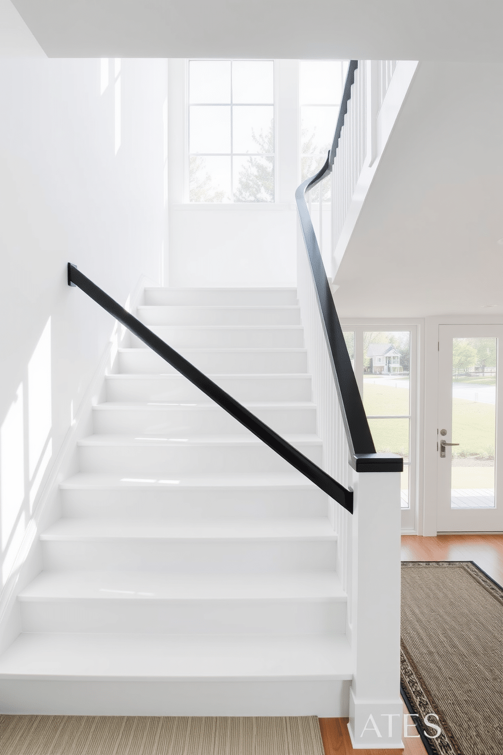 A stunning white staircase features sleek, minimalist lines that lead gracefully to the upper levels of the home. The contrasting dark handrail adds a touch of elegance, creating a striking visual impact against the bright white backdrop. The staircase is illuminated by natural light pouring in from large windows, highlighting the clean lines and modern design. Below, a stylish runner in a subtle pattern enhances the overall aesthetic while providing comfort and safety.