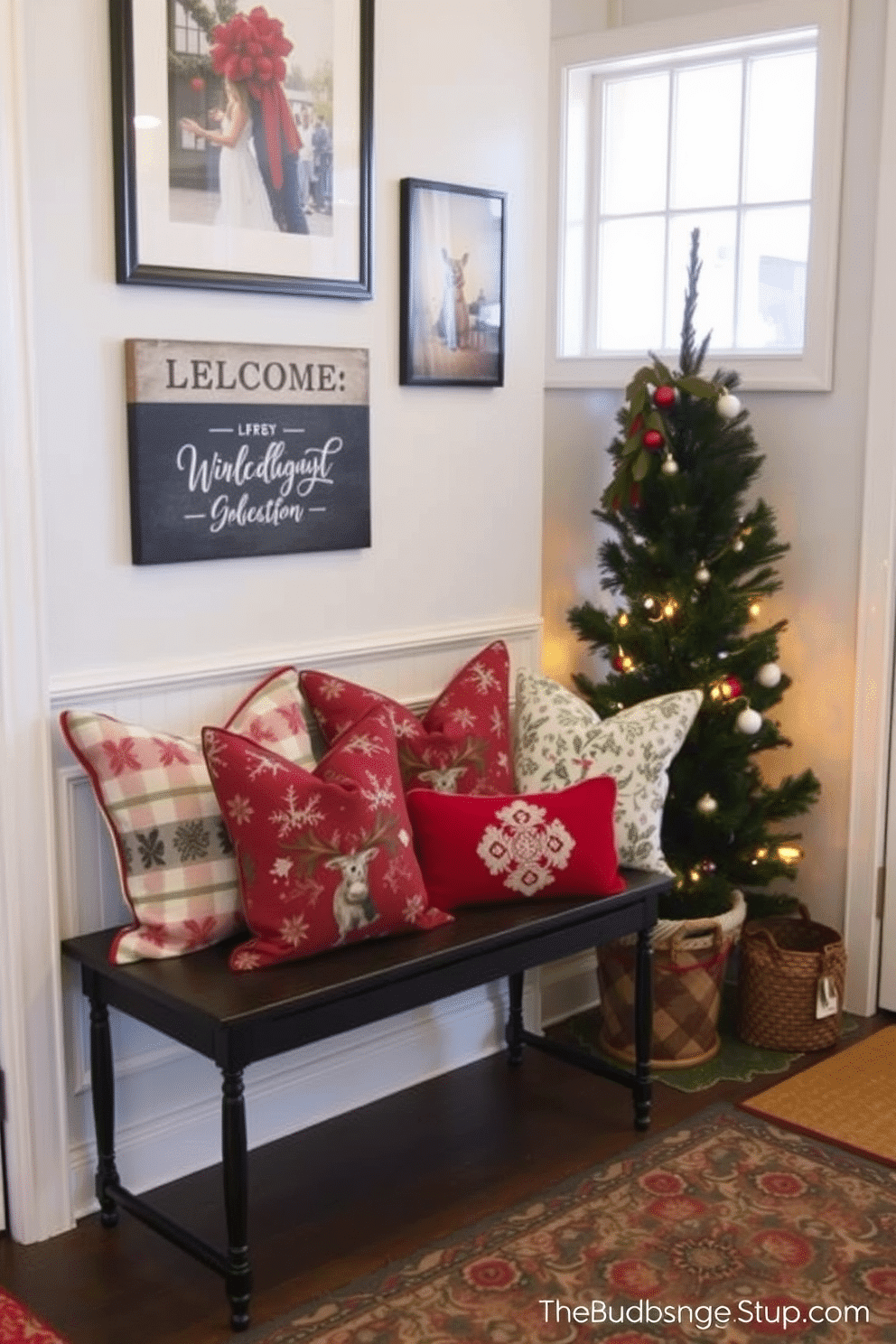 Warm throw pillows in festive patterns are arranged on a cozy bench by the entryway. The walls are adorned with holiday-themed artwork, and a small evergreen tree sits in the corner, creating a welcoming atmosphere.