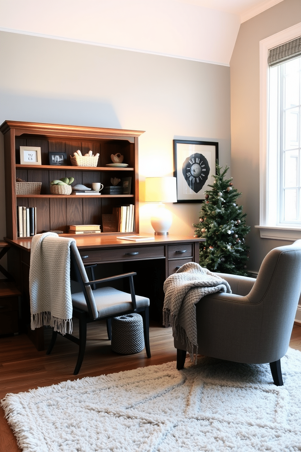 A cozy winter home office featuring a large wooden desk positioned near a window. The desk is adorned with a soft throw draped over the back and a stylish desk lamp providing warm light. The walls are painted in a soft gray hue, complemented by a plush area rug underfoot. A comfortable armchair sits in the corner, inviting relaxation with a knitted blanket folded over the arm.