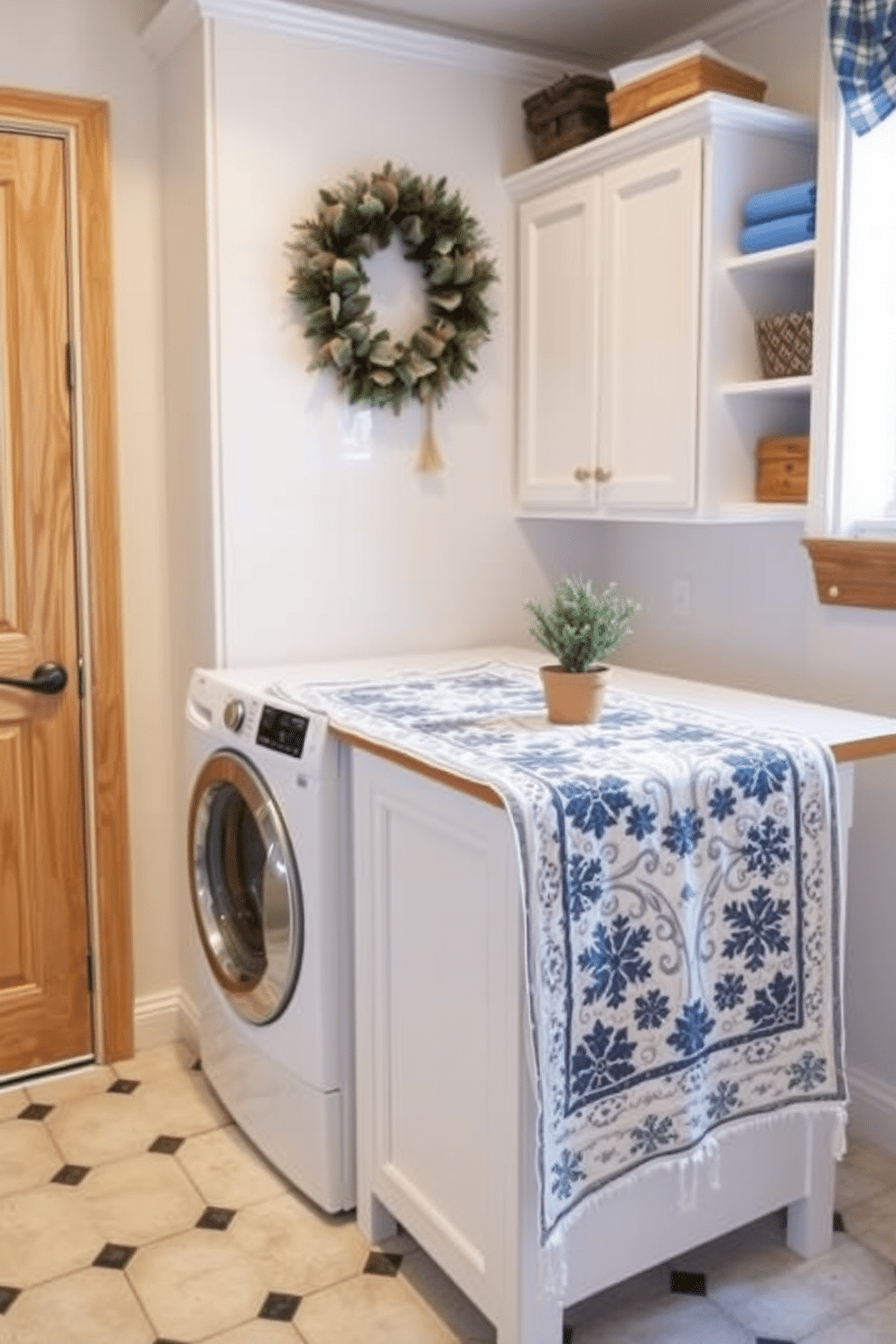 A cozy winter laundry room features a seasonal table runner draped over a folding area. The runner is adorned with snowflake patterns and rich blue hues, complementing the soft white cabinetry and warm wooden accents.