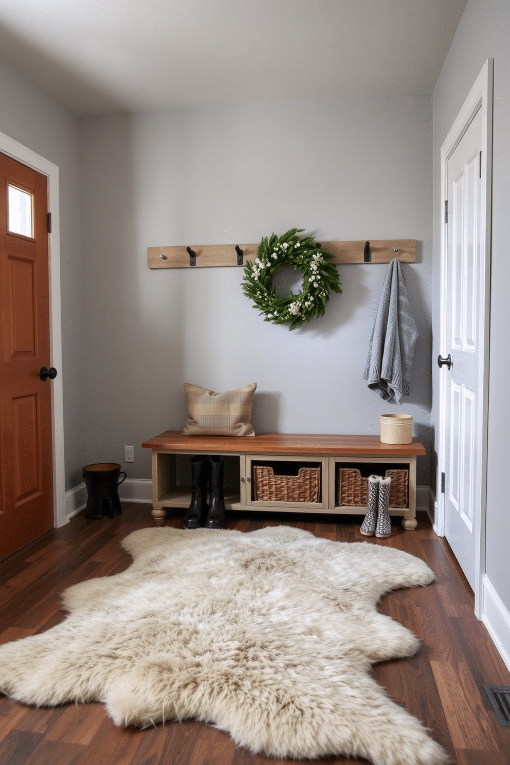 A cozy winter mudroom features a large faux fur rug that adds warmth and texture to the space. The walls are painted in a soft gray, and a wooden bench with storage underneath provides a practical seating area for putting on boots.