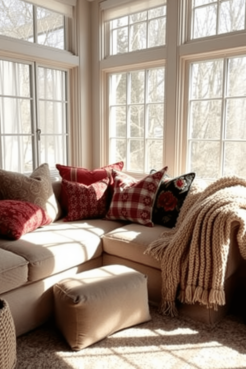 A cozy winter sunroom filled with natural light. The space features a mix of colorful throw pillows in various patterns and textures arranged on a plush sofa. Large windows with sheer curtains frame the room, allowing soft sunlight to filter in. A warm, knitted throw is draped over the arm of the sofa, adding an inviting touch to the decor.