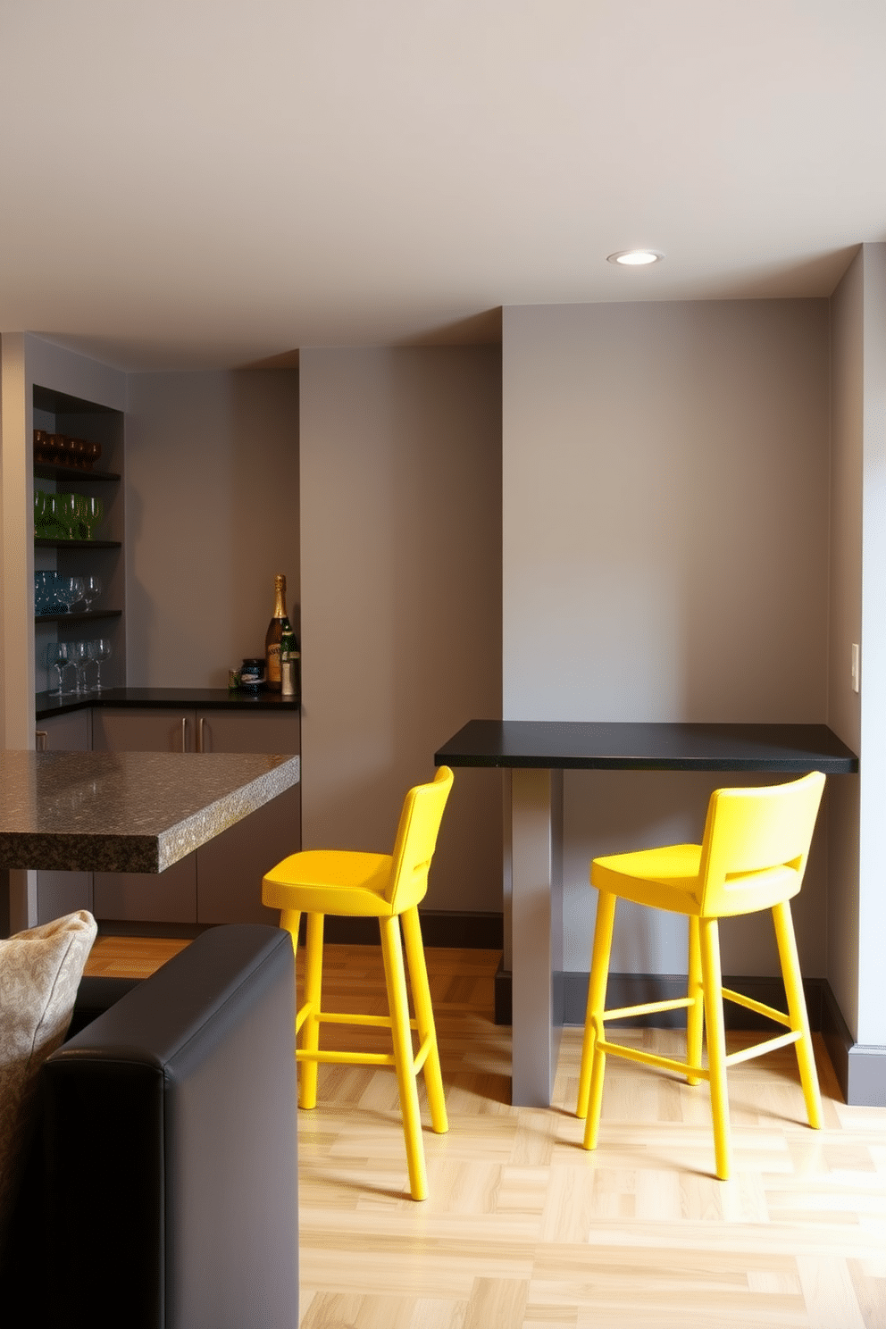 A lively basement space featuring vibrant yellow bar stools that add a playful element to the room. The walls are painted in a soft gray, providing a modern backdrop for the stylish seating arrangement. Incorporate a sleek wet bar with a polished countertop, complemented by open shelving displaying colorful glassware. The flooring is a warm wood finish, enhancing the inviting atmosphere of this entertaining space.