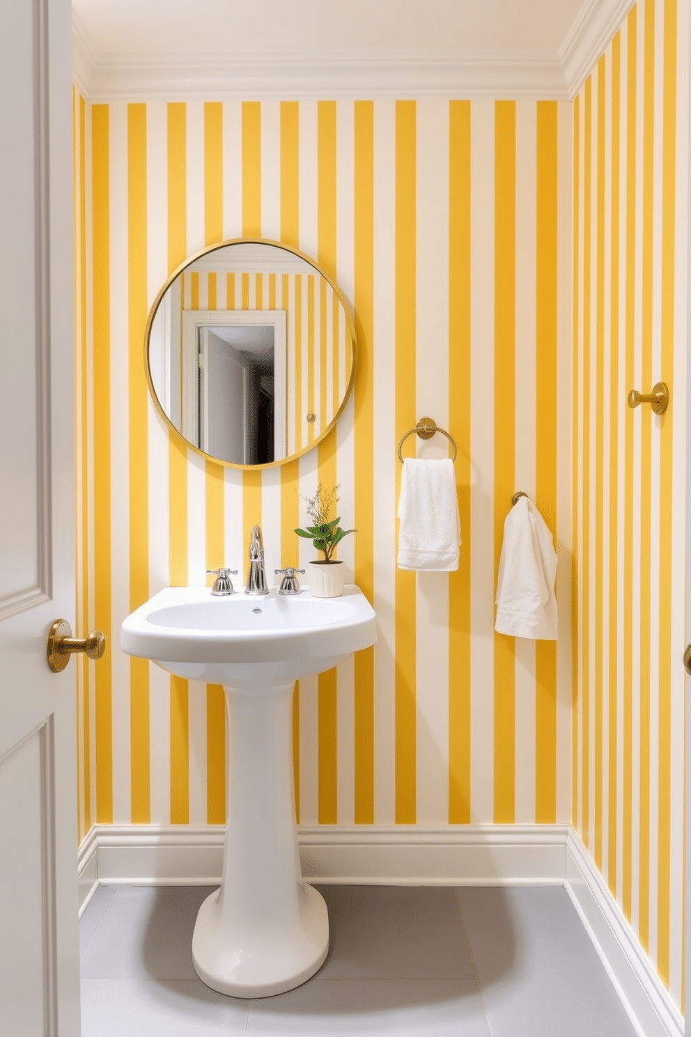 A chic powder room featuring yellow and white striped wallpaper that adds a vibrant yet elegant touch to the space. The room includes a sleek white pedestal sink with a polished chrome faucet, complemented by a round mirror with a simple gold frame. The flooring is a light gray tile that provides a subtle contrast to the wallpaper. Decorative elements include a small potted plant on the sink and a plush white towel neatly hung on a nearby hook.